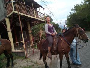 a woman riding a horse in front of a building at Beach cabin ometepe in Altagracia +105 photos