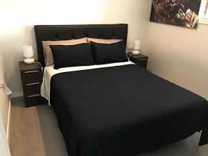 トレモリノスにあるIsabel Manoja Apartmentのベッドルーム1室(黒いベッド1台、ナイトスタンド2台付)