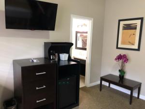 
a living room with a tv and a dresser at Knights Inn Los Angeles Central / Convention Center Area in Los Angeles
