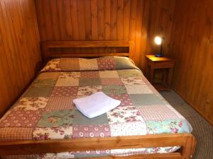 sypialnia z łóżkiem z kołdrą w obiekcie Hostal el Nogal Pucón w mieście Pucón