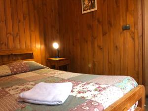 um quarto com uma cama com uma toalha branca em Hostal el Nogal Pucón em Pucón