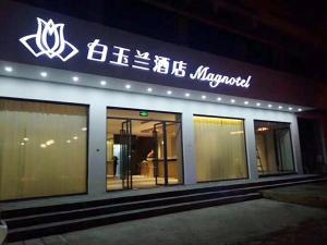 ein Gebäude mit einem Schild an der Seite in der Unterkunft Magnotel Yangshuo West Street in Yangshuo