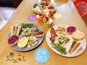 uma mesa de madeira com pratos de comida em Spring Enjoy Color B&B em Taitung City