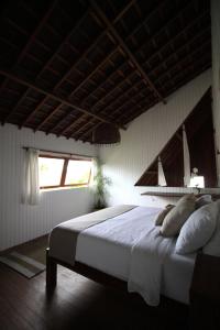 a bedroom with a large white bed with a window at Asmara Villa in Nusa Lembongan
