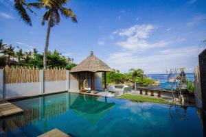 a swimming pool with a gazebo next to the ocean at Asmara Villa in Nusa Lembongan