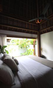 a bedroom with a large white bed with a window at Asmara Villa in Nusa Lembongan