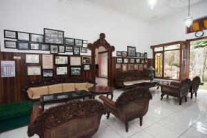 a living room filled with furniture and pictures on the wall at RedDoorz near Brawijaya University in Malang