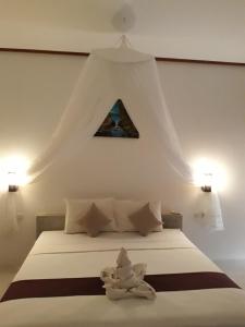 a bedroom with a white bed with a triangle above it at Sammy Homestay in Kuta Lombok