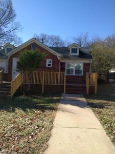 a red brick house with a fence and a sidewalk at The Right Side Duplex in Charlotte