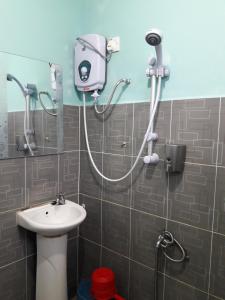 uma casa de banho com um chuveiro e um lavatório. em Canopy Inn em Jerantut