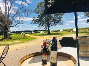 two bottles of wine sitting on a table with an umbrella at Coonawarra Ensuite Unit C in Coonawarra