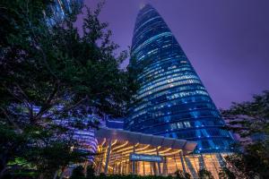 a tall building with a sign in front of it at Four Seasons Hotel Guangzhou-Free Shuttle Bus to Canton Fair Complex & Overseas Buyer Registration Services during Canton Fair Period in Guangzhou