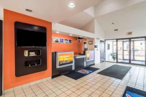 ハービーにあるMotel 6-Harvey, ILのオレンジ色の壁の客室で、薄型テレビが備わります。
