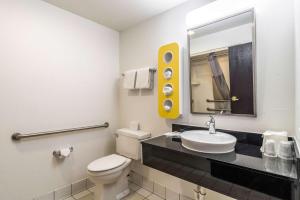 a bathroom with a toilet and a sink and a mirror at Motel 6-Harvey, IL in Harvey