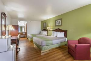 a hotel room with two beds and a chair at Rodeway Inn Santa Rosa in Santa Rosa +32 photos