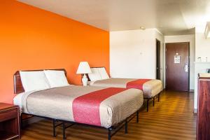 two beds in a room with orange walls at Motel 6-Newport, OR in Newport