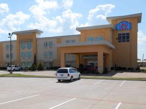 un coche aparcado en un aparcamiento frente a un edificio en Motel 6-Joshua, TX, en Joshua