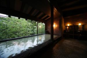 a room with a large window with water in it at Unzen Fukudaya in Unzen