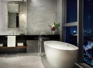 a bathroom with a tub and a view of a city at L7 Gangnam by LOTTE in Seoul