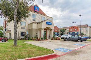 Un hotel con coches aparcados en un estacionamiento. en Studio 6-Dallas, TX, en Dallas