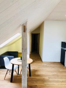 a room with a table and chairs in a attic at Villa Midesta in Šiauliai