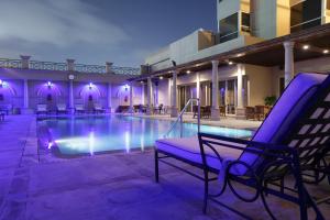 a pool with a purple chair next to a building at Chelsea Plaza Hotel in Dubai