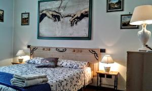カルディエーロにあるB&B Happy Days Veronaのベッドルーム1室(ベッド1台付)が備わります。壁には絵画が飾られています。