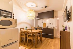 a kitchen and dining room with a table and a microwave at Bijou Suites Kokoro in Osaka