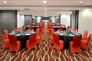 une salle de conférence avec des tables et des chaises rouges dans l'établissement Hotel Neo Palma Palangkaraya by ASTON, à Palangka Raya