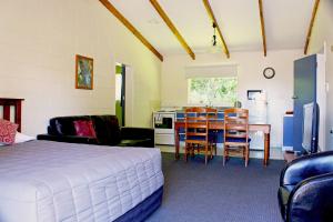 a bedroom with a bed and a table and a kitchen at Fairy Springs Motel in Rotorua +44 photos
