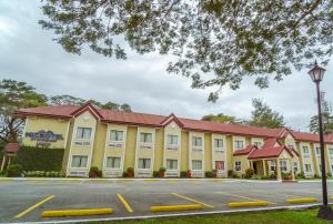 un gran edificio amarillo con techo rojo en Microtel by Wyndham Tarlac, en Tarlac