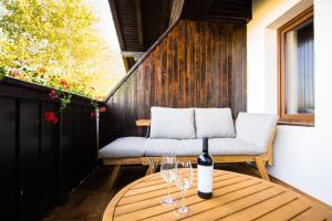 a table with a bottle of wine and glasses on a balcony at Bran Monte Crai Chalet in Bran