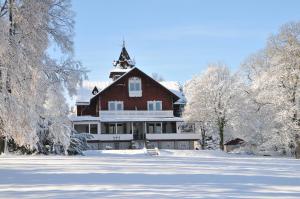 a large house in the snow with trees at Jagdschloss Fahrenbühl Hotel Garni in Kirchenlamitz