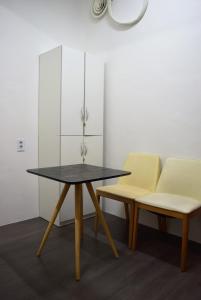 una mesa y dos sillas amarillas en una habitación en JK House, en Seúl
