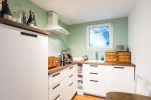 a kitchen with white cabinets and a window at Zur Burgstiege in Solingen