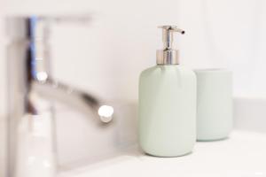 a white soap bottle sitting on a bathroom sink at Zur Burgstiege in Solingen