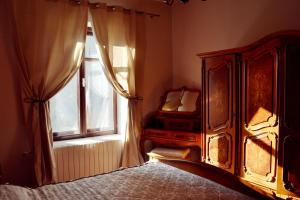 a bedroom with a bed and a window at Villa Castelul Maria in Banpotoc