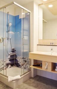 ein Bad mit einer Dusche und einem Waschbecken in der Unterkunft Hotel Nummerhof in Erding