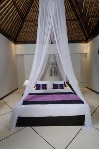 een slaapkamer met een bed met een klamboe bij Villa Maju in Seminyak