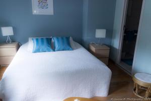 - une chambre avec un lit blanc et 2 oreillers bleus dans l'établissement Confluences, à Walcourt