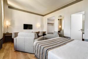 a hotel room with two beds and a television at Hotel Orto de' Medici in Florence