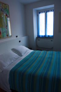 a bed with a striped blanket in a bedroom at Hotel Gianni Franzi in Vernazza