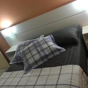 ein Bett mit zwei Kissen auf einem Zimmer in der Unterkunft Apartamento Centro dos Ingleses in Florianópolis