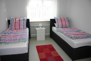 a bedroom with two beds and a red rug at ApartmentBuyMetzingen in Riederich