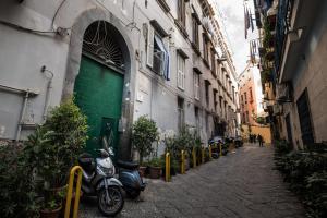uma scooter estacionada num beco ao lado de um edifício em Casa Le Volte em Nápoles