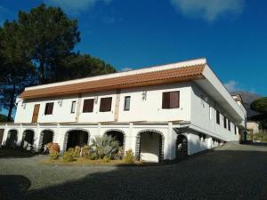 a large white building with a red roof at Hotel Sirio in Boscotrecase