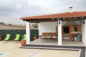a pavilion with chairs and a table on a patio at Casas de São Lázaro in Juromenha