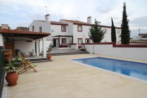 a villa with a swimming pool and a house at Casas de São Lázaro in Juromenha