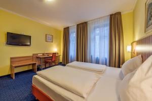 Habitación de hotel con 2 camas y escritorio en Hotel Windsor, en Colonia