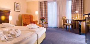 een hotelkamer met twee bedden en een tafel bij Akzent Hotel Höltje in Verden +20 foto's